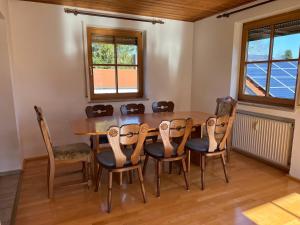 a dining room with a wooden table and chairs at Ferienplatzl 90m2 in Peißenberg
