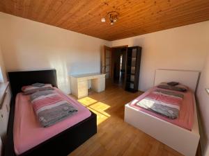 a room with two beds and a desk in it at Ferienplatzl 90m2 in Peißenberg