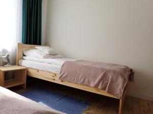 ein Holzbett in einem Zimmer mit Fenster in der Unterkunft hutApart Nowa Huta in Krakau
