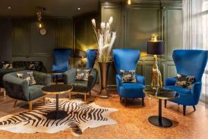 ein Wohnzimmer mit blauen Stühlen und einem Zebra-Teppich in der Unterkunft Amedia Hotel & Suites Leipzig, Trademark Collection by Wyndham in Leipzig