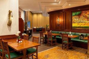 um restaurante com mesas de madeira e cadeiras verdes em Amedia Hotel & Suites Leipzig, Trademark Collection by Wyndham em Leipzig