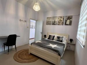 1 dormitorio con cama, escritorio y silla en Eden Villa en Flic-en-Flac