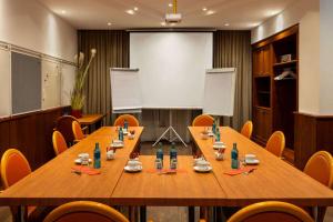 a conference room with a large wooden table and chairs at Amedia Hotel & Suites Leipzig, Trademark Collection by Wyndham in Leipzig