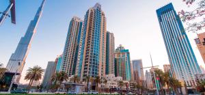 a city with tall skyscrapers and palm trees at BEST OFFER! One Bedroom with Downtown Views in Dubai