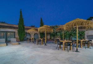 a group of tables and chairs with straw umbrellas at Alqueria de Vilches in Cullera