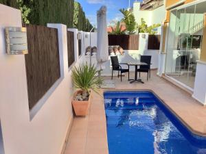 um pátio com uma piscina, uma mesa e cadeiras em Mar menor golf detached Villa em Torre-Pacheco