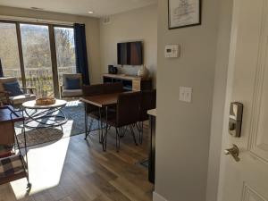 a living room with a table and chairs and a television at Downtown Traverse City Condo - Capri 209 in Traverse City