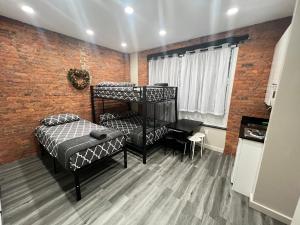 a bedroom with two bunk beds and a brick wall at 31 Street Broadway Hotel in New York