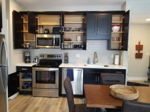 a kitchen with stainless steel appliances and a wooden table at Spacious Condo Downtown Traverse City in Traverse City +22 photos