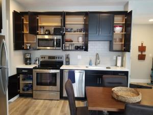 a kitchen with stainless steel appliances and a wooden table at Downtown Traverse City Condo - Capri 209 in Traverse City