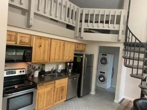 a kitchen with a sink and a kitchen with a staircase at Boyne Mountain Condo -Sleeps 12 in Boyne Falls