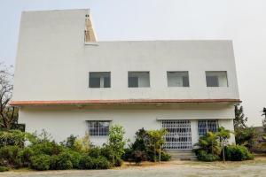 丹巴德Hotel O The Nirvana Resorts的上面有十字架的白色建筑