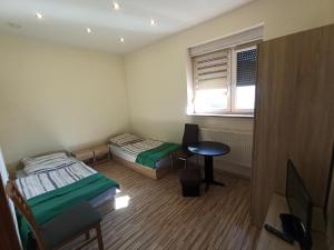 Zimmer mit 2 Betten, einem Tisch und einem Fenster in der Unterkunft Mieszkanie na Wsi in Targowagórka