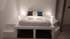 a bedroom with a white bed with two boxes on it at Appartamento Nido Vista Lago in Padenghe sul Garda