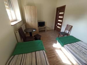 ein kleines Zimmer mit 2 Betten, einem Tisch und Stühlen in der Unterkunft Mieszkanie na Wsi in Targowagórka