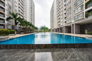 a large swimming pool in the middle of two buildings at Lena Condotel in Ho Chi Minh City