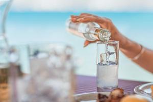 a person is pouring a drink into a glass at Villa Paradiso - Breathtaking Seaview in Iraion