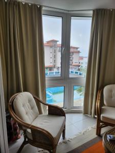 a living room with two chairs and a large window at St. Vlas apartment in Sveti Vlas