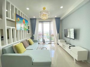 a living room with a couch and a tv at Lena Condotel in Ho Chi Minh City