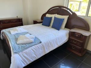 a large bed with blue pillows and towels on it at NICE and MODERN FLAT NEAR AIRPORT in Santa Cruz