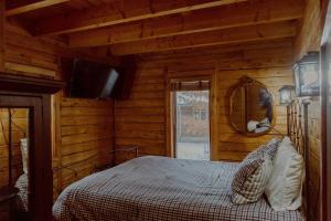 a bedroom with a bed in a wooden cabin at Crystal Mountain Cabin Get Away in Thompsonville