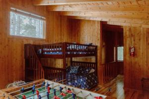 two bunk beds in a room with a pool table at Crystal Mountain Cabin Get Away in Thompsonville