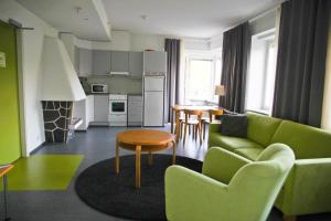 a living room with a green couch and a table at Huoneistohotelli Valo in Heinola