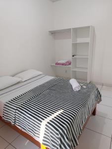 a bedroom with a black and white bed and a shelf at Hotel Monte Arau in Boa Vista
