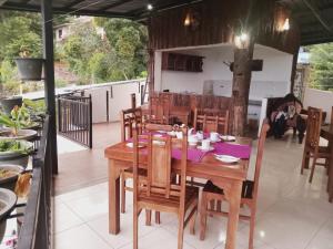 una sala da pranzo con tavolo e sedie in legno di Kandy IVY Mountain View Resort a Kandy