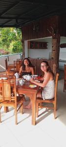 twee vrouwen aan een tafel in een restaurant bij Kandy IVY Mountain View Resort in Kandy