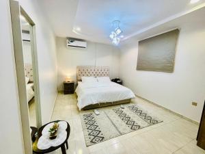a bedroom with a white bed and a table and a mirror at Haven in Makkah