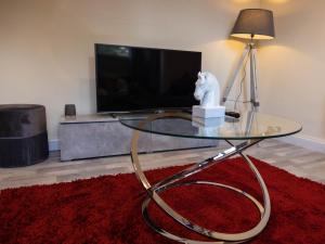 a glass coffee table with a horse statue on top of it at Pristine Relocation Flat 1 in London