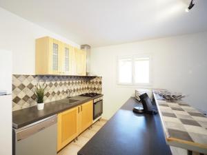 une cuisine avec des armoires jaunes et un comptoir noir dans l'établissement GITE DE LA TRUFFIERE "Les Chênes", à Montagnac