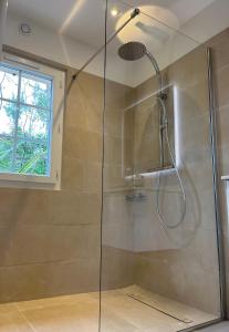 um chuveiro com uma porta de vidro na casa de banho em Le Refuge em La Croix-Valmer