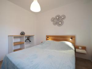 - une chambre avec un lit blanc et un éclairage dans l'établissement GITE DE LA TRUFFIERE "Les Chênes", à Montagnac