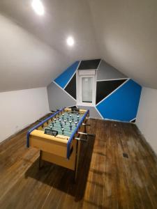 a room with a foosball table in the attic at Belle Suite privative centre vesoul in Vesoul