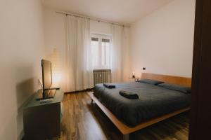 een slaapkamer met een groot bed en een televisie bij Arena Luxury Apartment in Verona