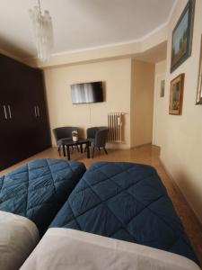 1 dormitorio con 2 camas y sala de estar con mesa. en Appartamento Fiore Roma Cinecittà en Roma