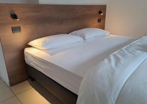 een groot wit bed met 2 kussens erop bij GUEST ROOM GRADONOVE in Arco