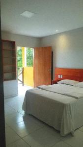 a bedroom with a large bed in a room at Tambazulik pousada in Maragogi