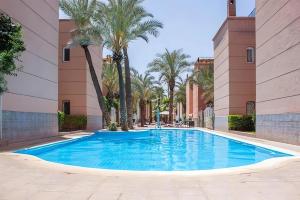een zwembad in het midden van een gebouw met palmbomen bij Riad Paolo Piscine Palmeraie in Marrakesh