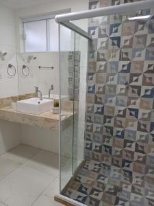y baño con lavabo y ducha acristalada. en Apartamento família a 10 mim da Praia do Forte em Cabo Frio, en Cabo Frío