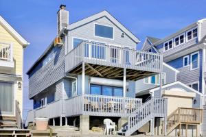 a large house with a deck on the side of it at Cheerful 3 Bedroom Beach Front Cottage with Fire Place in Milford
