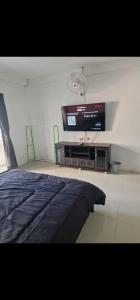 a bedroom with a bed and a flat screen tv at Paradise Bar & Guesthouse in Pattaya South