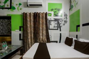- une chambre avec un lit et un mur vert dans l'établissement OYO Home 82227 Malik Hotel, à Jīnd