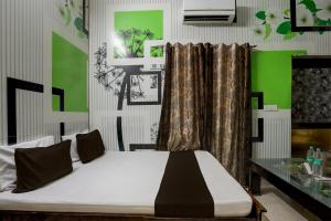 Un pat sau paturi într-o cameră la OYO Home 82227 Malik Hotel