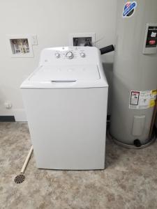 a white washing machine sitting next to a trash can at Grand Traverse Commons Condo in Traverse City