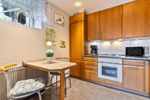 eine Küche mit Holzschränken und einem Tisch mit Stühlen in der Unterkunft Haus Monterosa in Baden-Baden