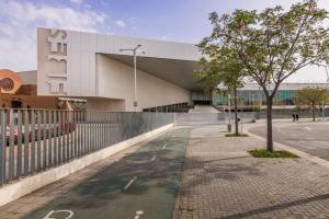 einen Gehweg vor einem Gebäude mit einem Baum in der Unterkunft Elegante y nuevo apartamento junto al Palacio Congresos in Sevilla