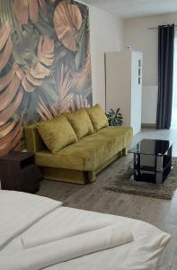 a living room with a couch and a painting at Habán Lux Apartmanház in Hévíz